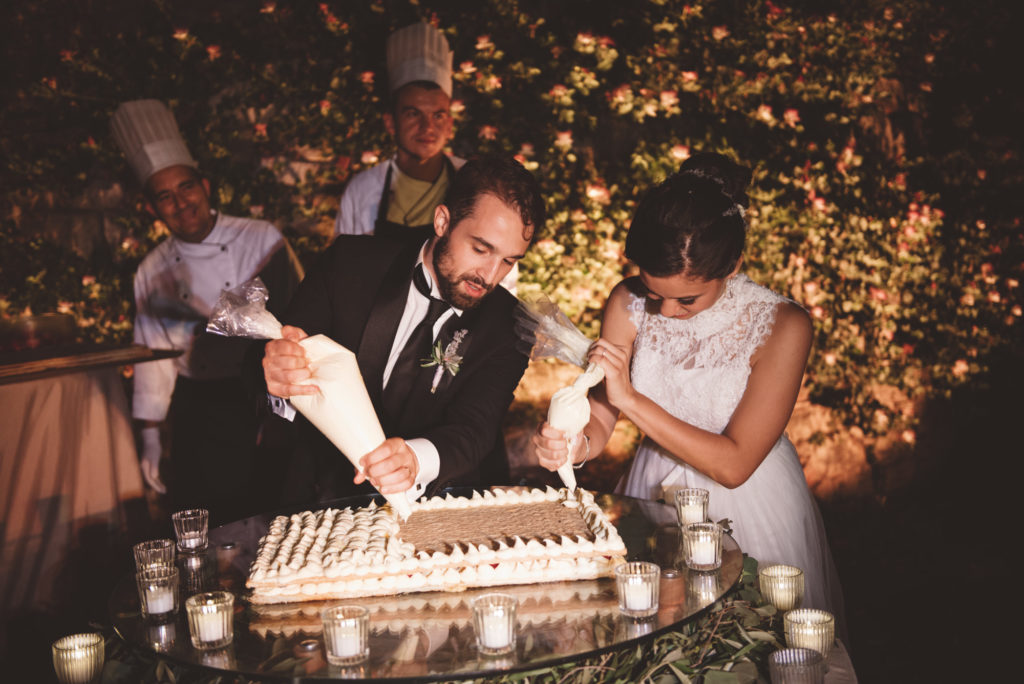 Wedding couple doing wedding cake- Wedding at Castello di Meleto - Italian Wedding Designer